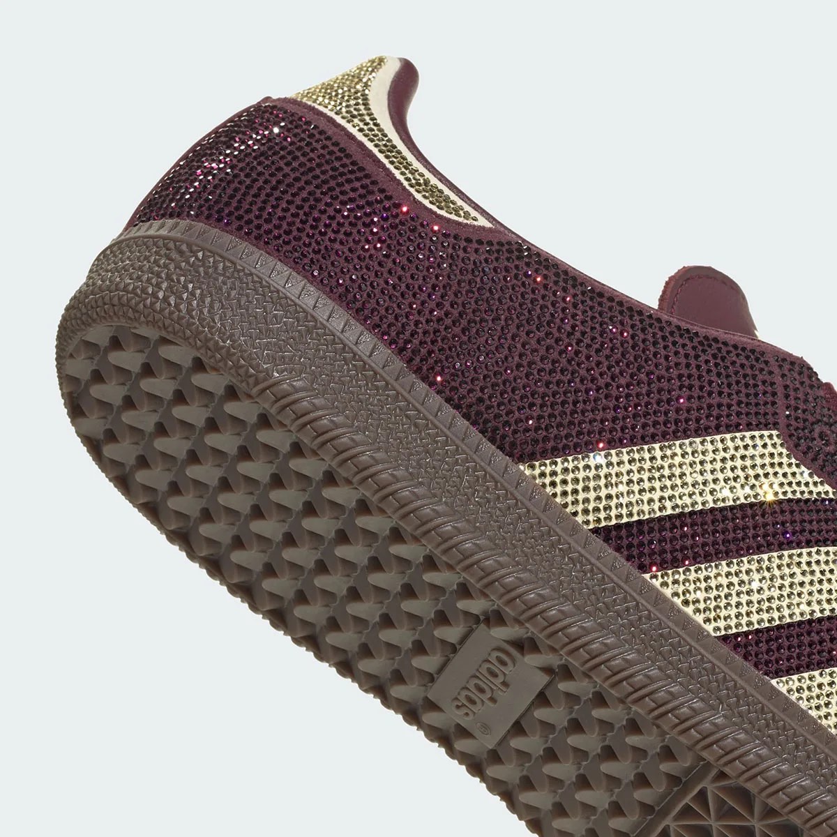 Detalle del talón de la adidas Samba OG Rhinestone Maroon/Gold, con los strass bordó y dorados de cerca y la suela de goma marrón con el logo de adidas