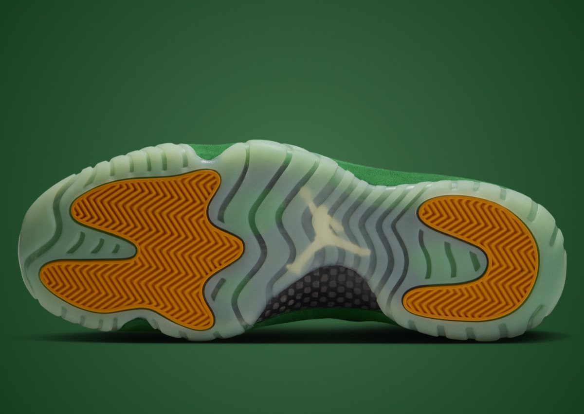 Suela del Air Jordan 11 Green Screen, translúcida en tono verde agua, con pods de tracción naranjas en la punta y el talón y un Jumpman en el centro