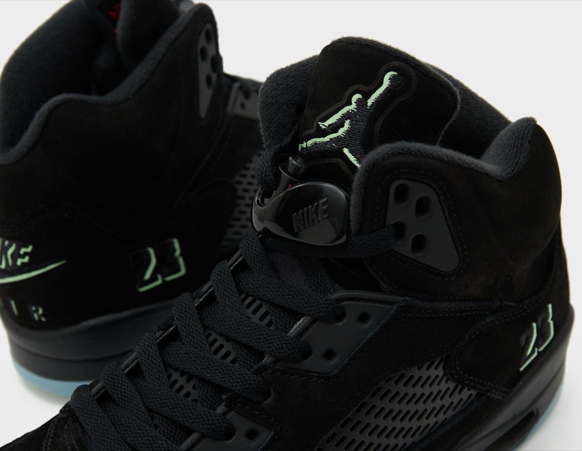 Detalle del Air Jordan 5 Halloween con el Jumpman de la lengüeta, el 23 bordado y el Nike Air del talón en verde fosforescente sobre gamuza negra