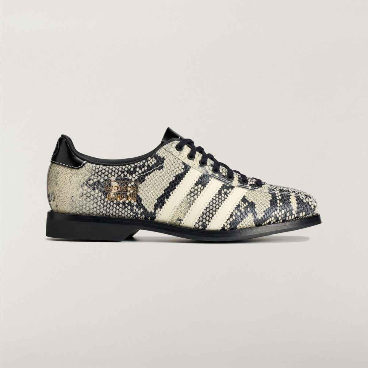 Brain Dead x adidas Samba Bowling Snakeskin de perfil lateral sobre fondo gris claro, con textura de piel de serpiente en crema y negro, tres tiras crema, logo adidas Bowling grabado en dorado, talón de charol negro y suela negra gruesa