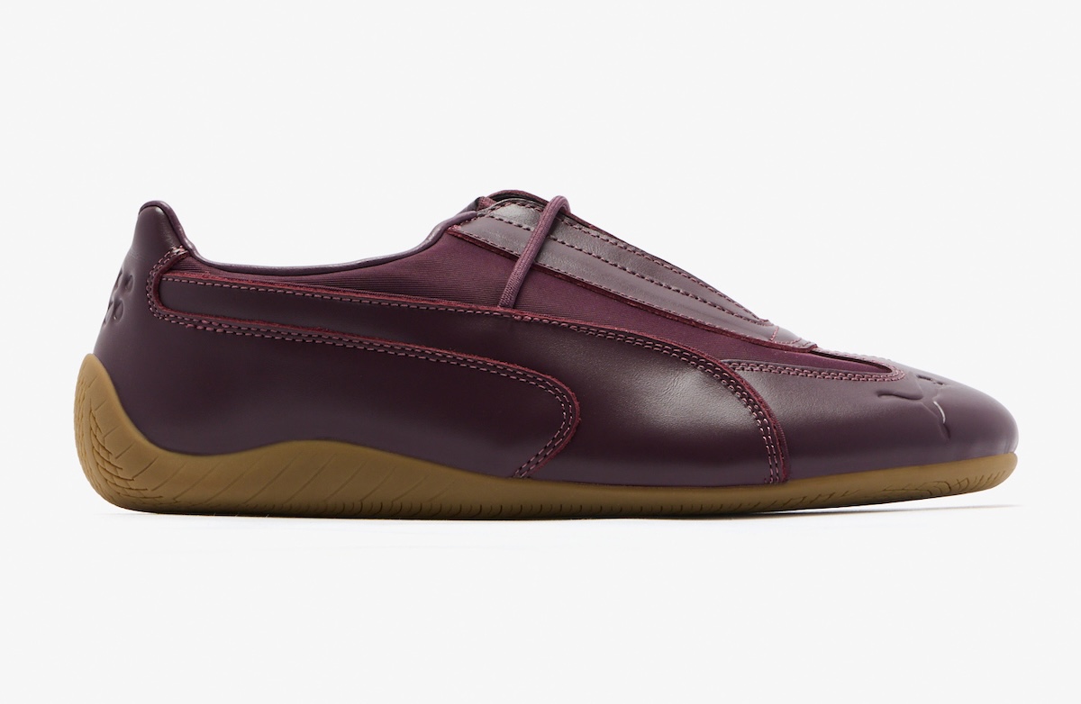PUMA Speedcat Slip-On de Daniëlle Cathari de perfil sobre fondo blanco, con upper de cuero bordó amarronado, costuras a la vista, panel textil en el empeine y suela de goma gum
