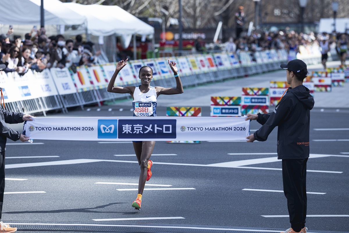 Foto de archivo: Brigid Kosgei, con musculosa blanca y zapatillas naranjas, levanta los brazos al cortar la cinta de llegada del Maratón de Tokio 2026