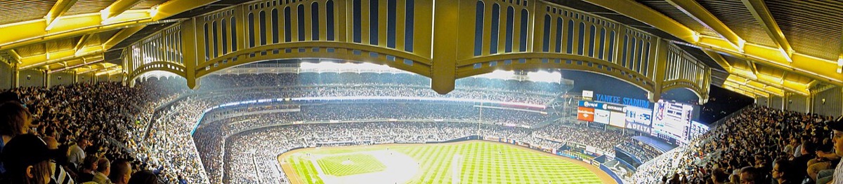 Foto de archivo: vista panorámica de Yankee Stadium de noche, con las tribunas llenas y el friso del techo iluminado