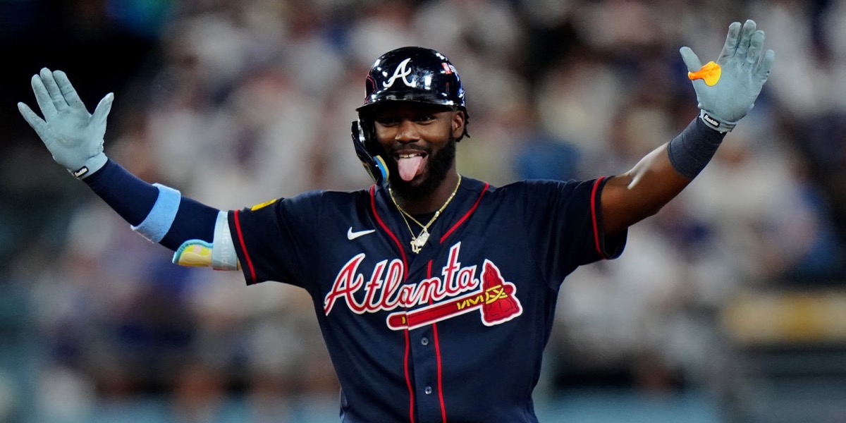 Michael Harris II, de los Braves, con casco y camiseta azul de Atlanta, festeja con los brazos abiertos y la lengua afuera en Dodger Stadium