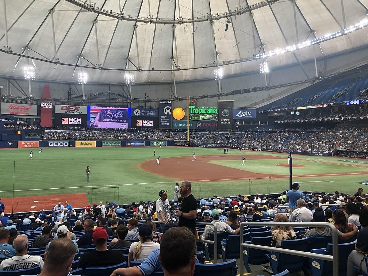 Foto de archivo: vista interior de Tropicana Field, con el techo fijo iluminado, las tribunas con público y los jugadores de los Rays en el campo