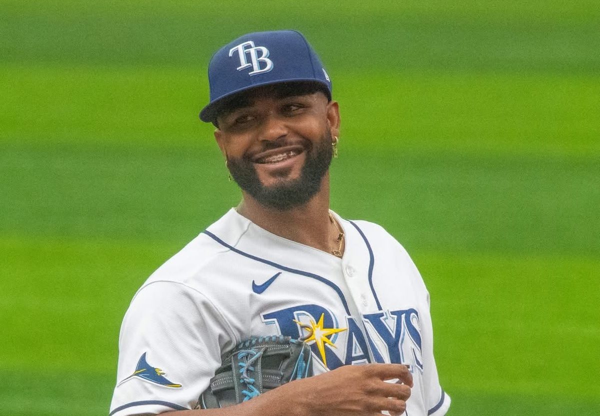 Foto de archivo: Junior Caminero sonríe en el campo con la camiseta blanca de los Tampa Bay Rays, la gorra azul con las letras TB y el guante en la mano