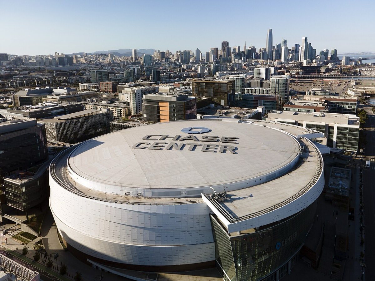 Vista aérea del Chase Center, el estadio de los Golden State Warriors, con su techo blanco y el centro de San Francisco de fondo
