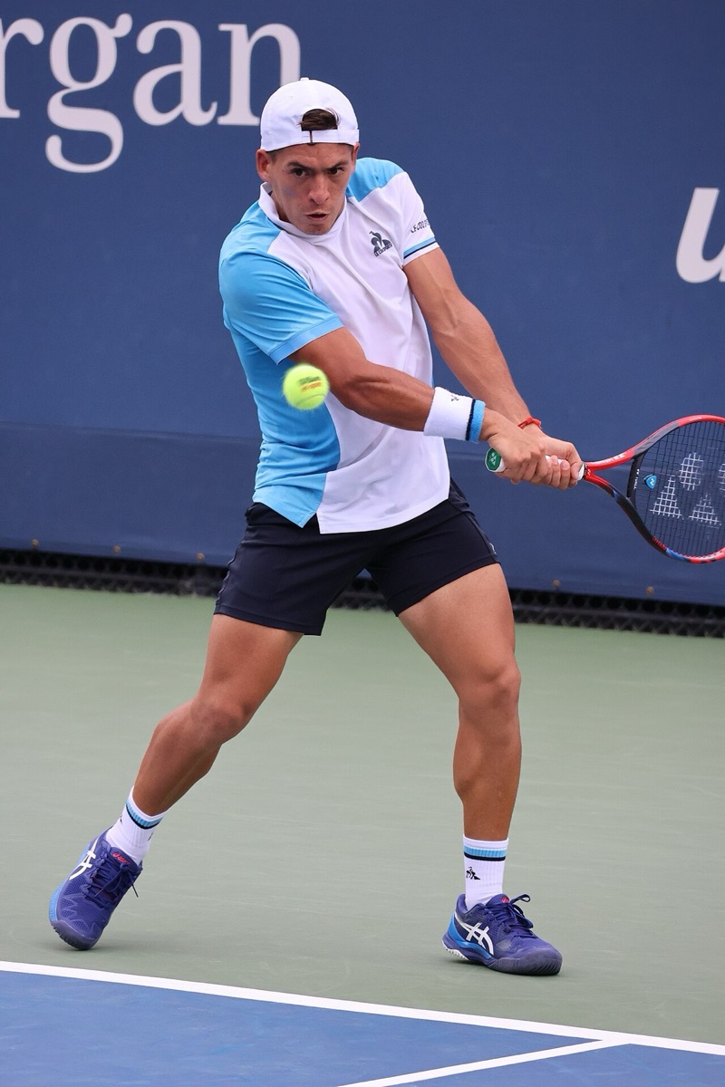 Foto de archivo: Sebastián Báez, con gorra blanca y remera celeste y blanca, pega un revés de dos manos en el US Open