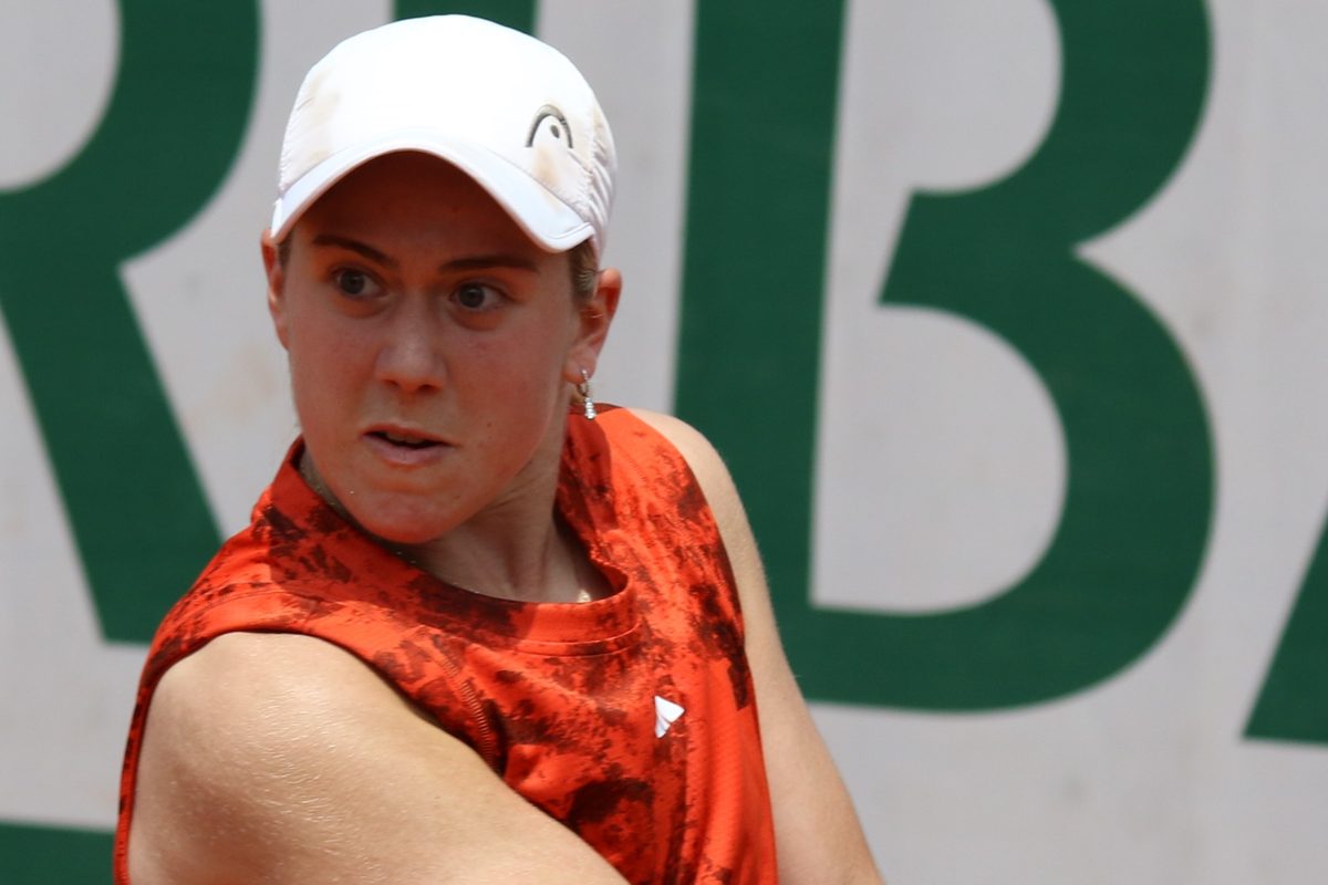 Foto de archivo: Sonay Kartal, con gorra blanca y remera naranja estampada, mira la pelota mientras prepara un golpe en la clasificación de Roland Garros 2023