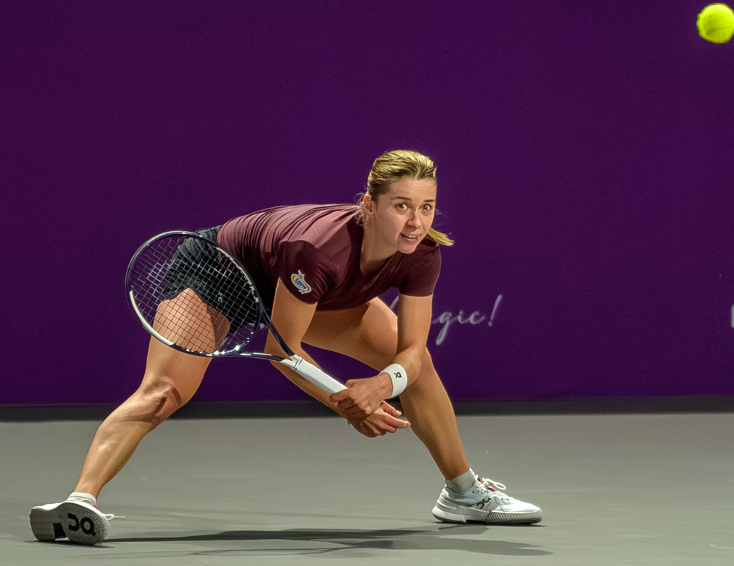 Foto de archivo: Maja Chwalinska, con remera bordó, se estira con la raqueta para devolver una pelota baja en el Transylvania Open 2026