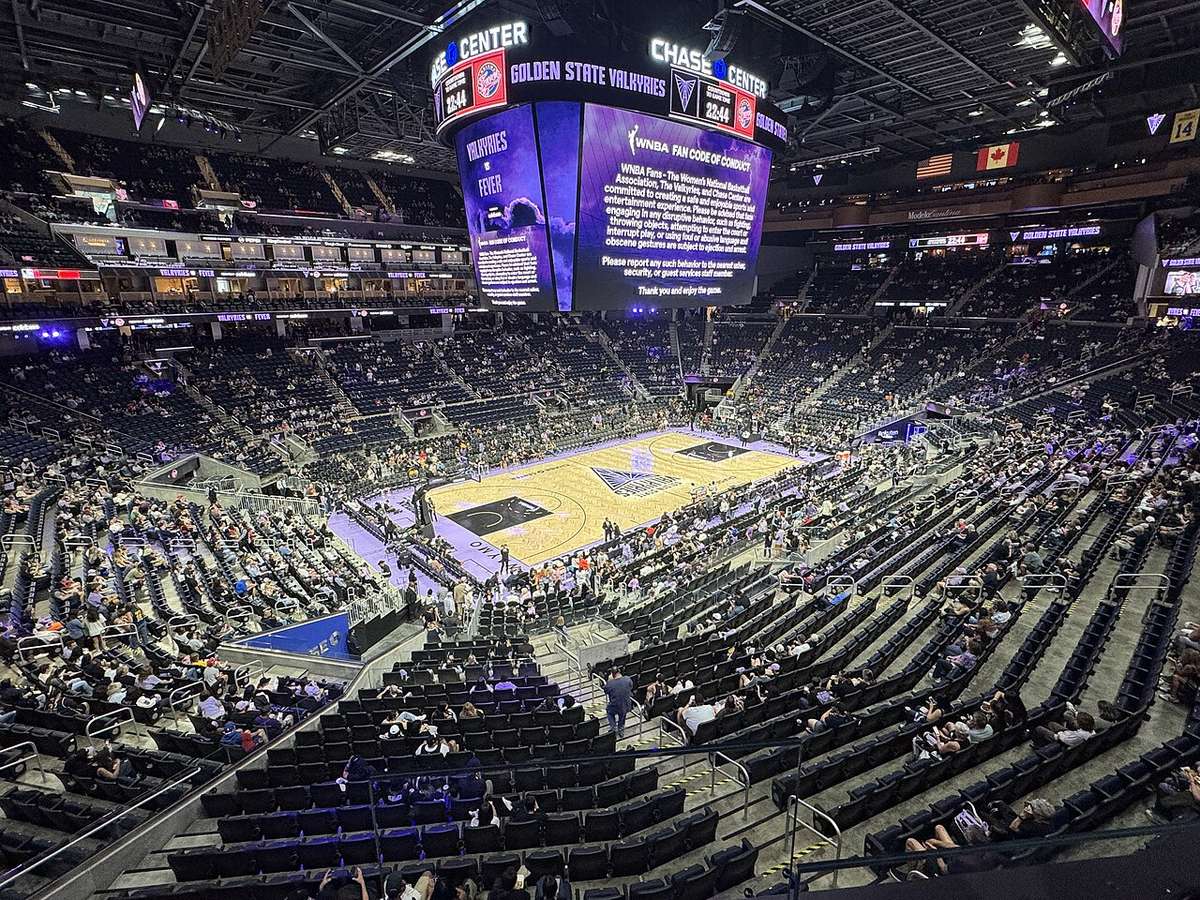Foto de archivo: el Chase Center de San Francisco desde lo alto de la tribuna antes de un partido de Golden State Valkyries, con la cancha lila y dorada en el centro y la pantalla gigante con el logo del equipo