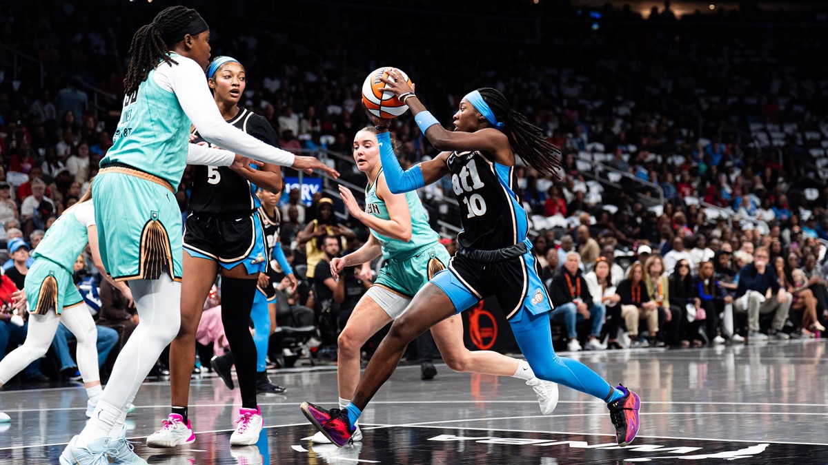 Rhyne Howard, con la camiseta negra número 10 del Atlanta Dream, ataca el aro entre jugadoras de New York Liberty mientras Angel Reese, con el número 5, sigue la jugada