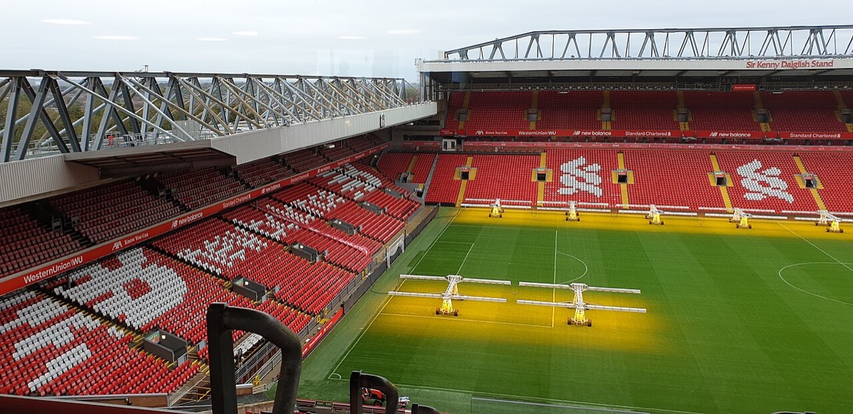 Las tribunas rojas de Anfield con el Sir Kenny Dalglish Stand de fondo y las lámparas de crecimiento sobre el césped; foto de archivo de octubre de 2019 (foto: Christine Matthews, Wikimedia Commons, licencia CC BY-SA 2.0)