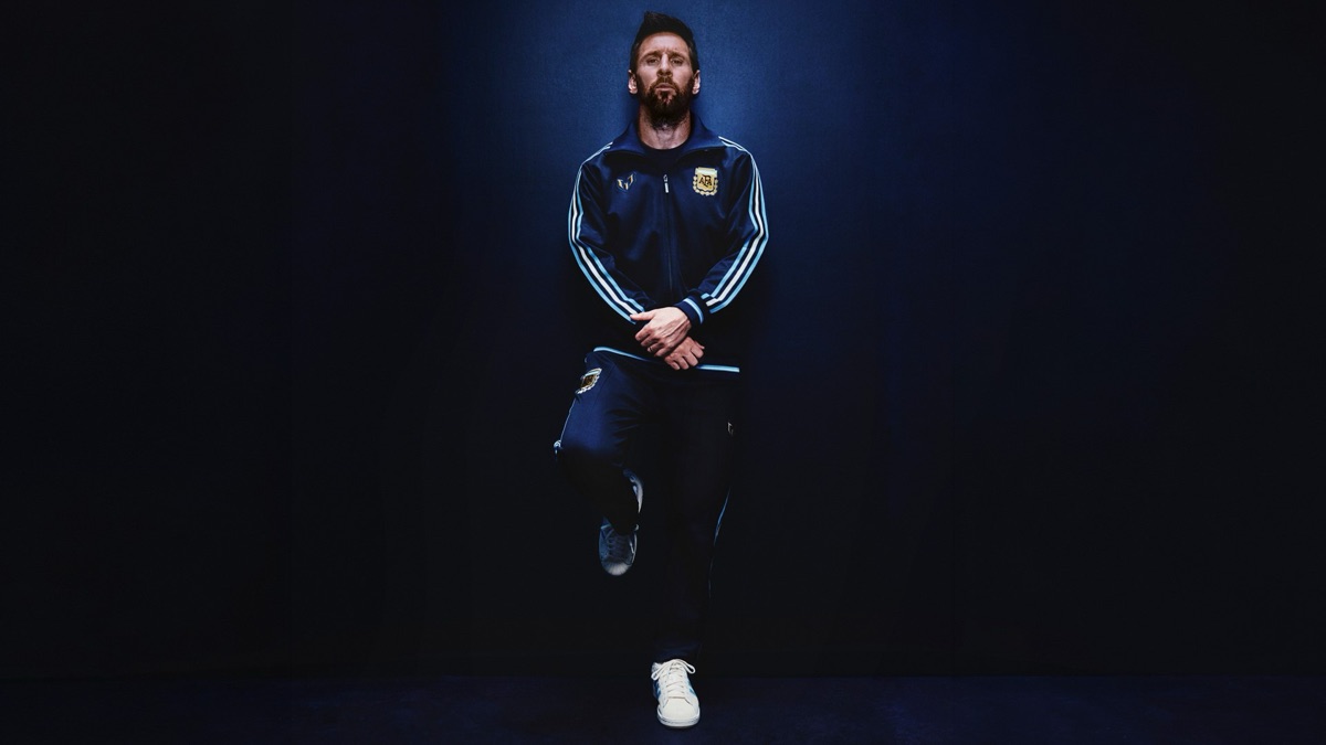 Lionel Messi con la campera y el pantalón azul marino de la línea urbana de la colección, con el escudo de la AFA y su emblema personal en el pecho (foto oficial de adidas)