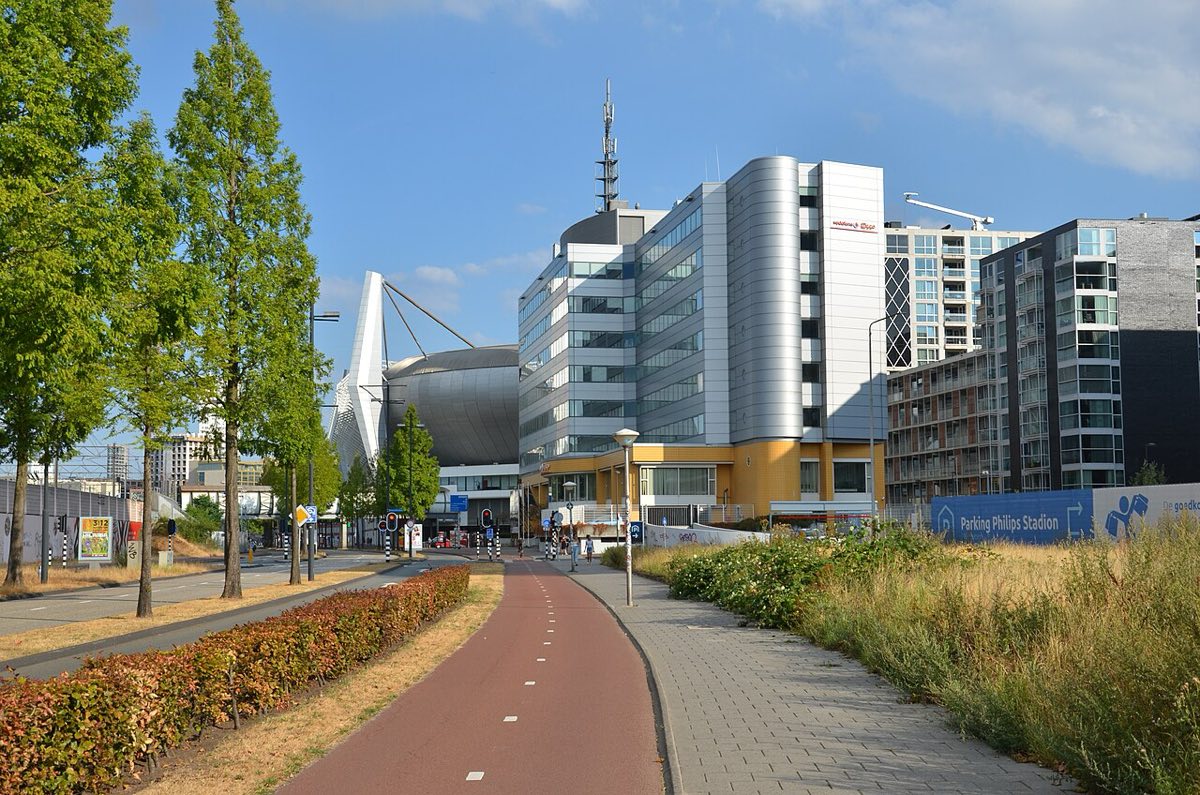 Vista del Philips Stadion de Eindhoven desde la calle, con la bicisenda y los edificios de la zona en primer plano (foto de archivo: Steven Lek, Wikimedia Commons, CC BY-SA 4.0)