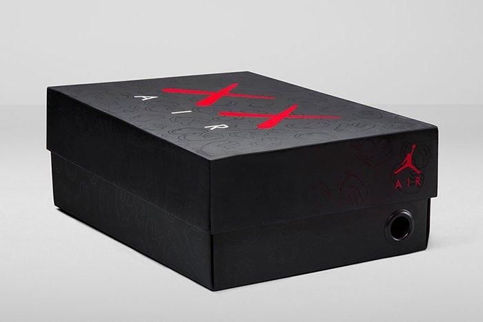 Foto de archivo: caja negra del KAWS x Air Jordan 4 de 2017, con el logo XX en rojo, la palabra AIR en blanco, las manos de KAWS grabadas en relieve y el Jumpman rojo en el costado
