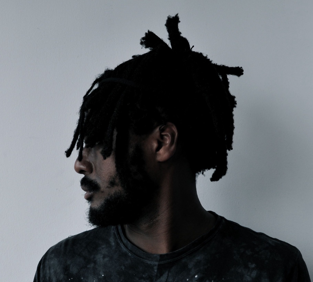 Foto de archivo: retrato de prensa de k-os de 2011, de perfil, con rastas y remera oscura frente a una pared gris. Foto: Nettwerk Artist Management (Monika Selnar), CC BY-SA 3.0, vía Wikimedia Commons