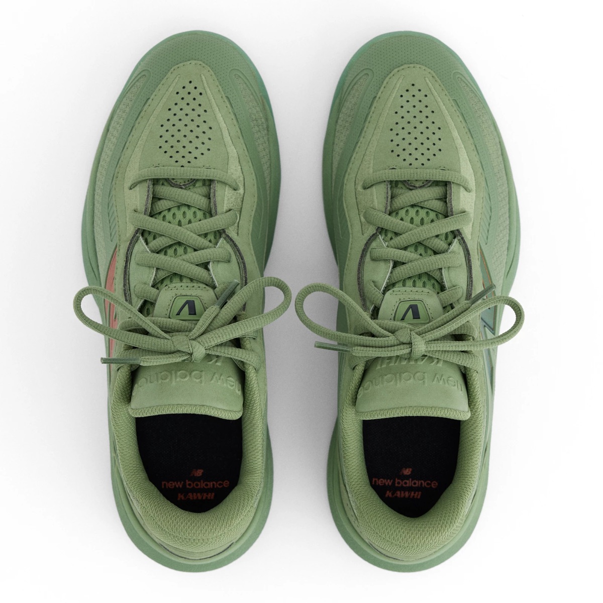 Vista desde arriba del par de New Balance Kawhi 5 Oregano, en verde salvia, con la puntera perforada, la lengüeta con el logo de New Balance, cordones verdes y plantillas negras con las palabras new balance y KAWHI