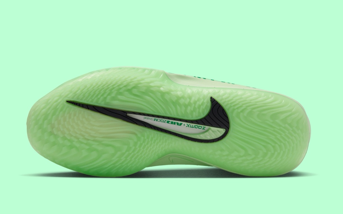 Suela del Nike GT Cut 4 Halloween sobre fondo verde agua: goma verde semitranslúcida con tracción de líneas onduladas, un swoosh negro grande y una ventana que muestra las leyendas ZoomX y Air Zoom Strobel