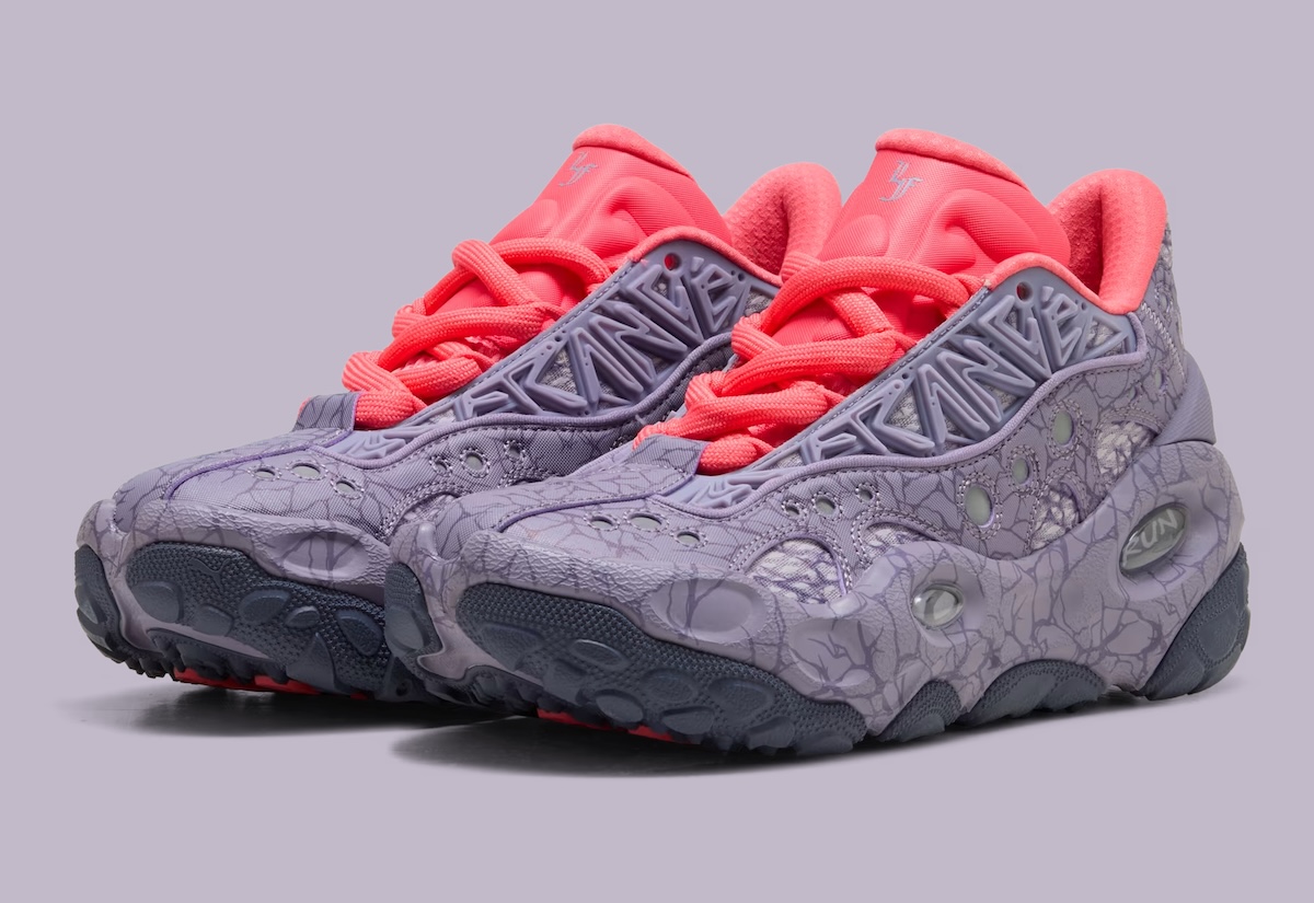 Par de PUMA LaFrancé RNR Stranger Things sobre fondo lila, con upper violeta claro cubierto de grietas, perforaciones circulares, letras en relieve sobre el empeine, cordones gruesos y lengüeta en rojo coral, y suela gris oscuro con tacos redondeados