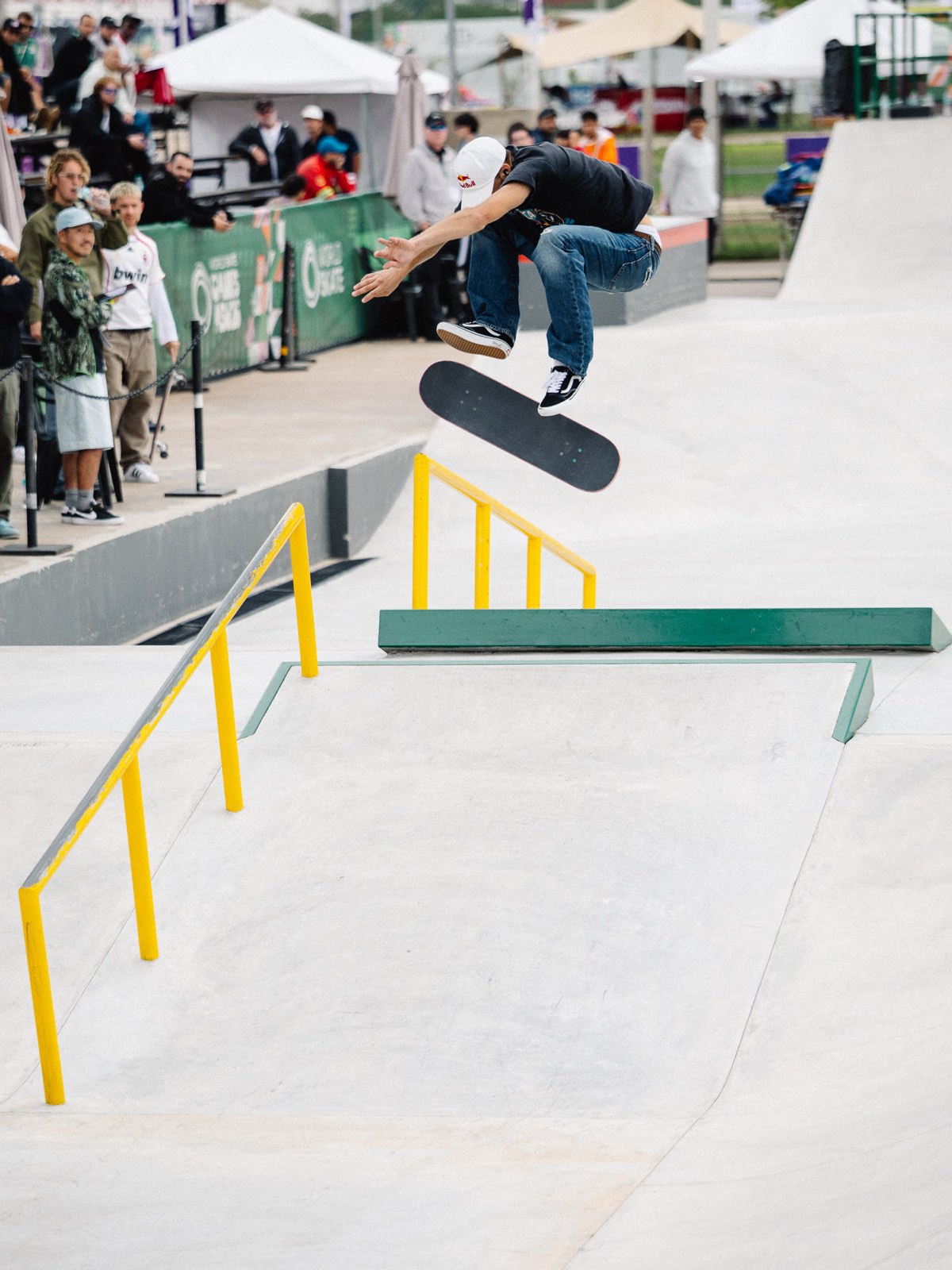 Jagger Eaton vuela con la tabla girando debajo de sus pies sobre la pista de street del Parque Olímpico de Luque, con público detrás de las vallas