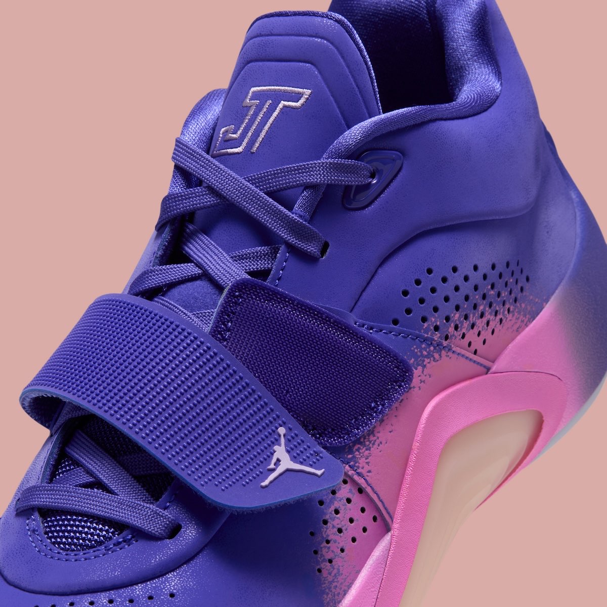 Detalle del Jordan Tatum 5 Sunrise con el strap violeta y el Jumpman, los cordones, el logo JT en la lengüeta y las perforaciones sobre el degradé rosa
