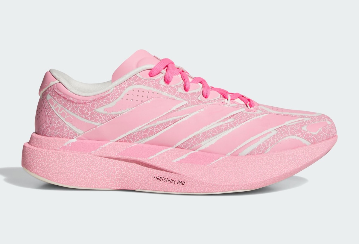 Adidas Adizero Evo SL Exo de The Whitaker Group en rosa, de perfil sobre fondo gris claro, con estampado agrietado en el upper y la mediasuela, cordones fucsia y la leyenda Lightstrike Pro en la mediasuela